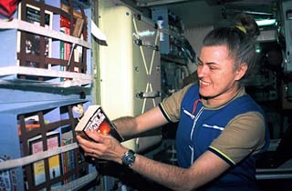 Lucid picks a book out of her bookrack in the Spektr module.